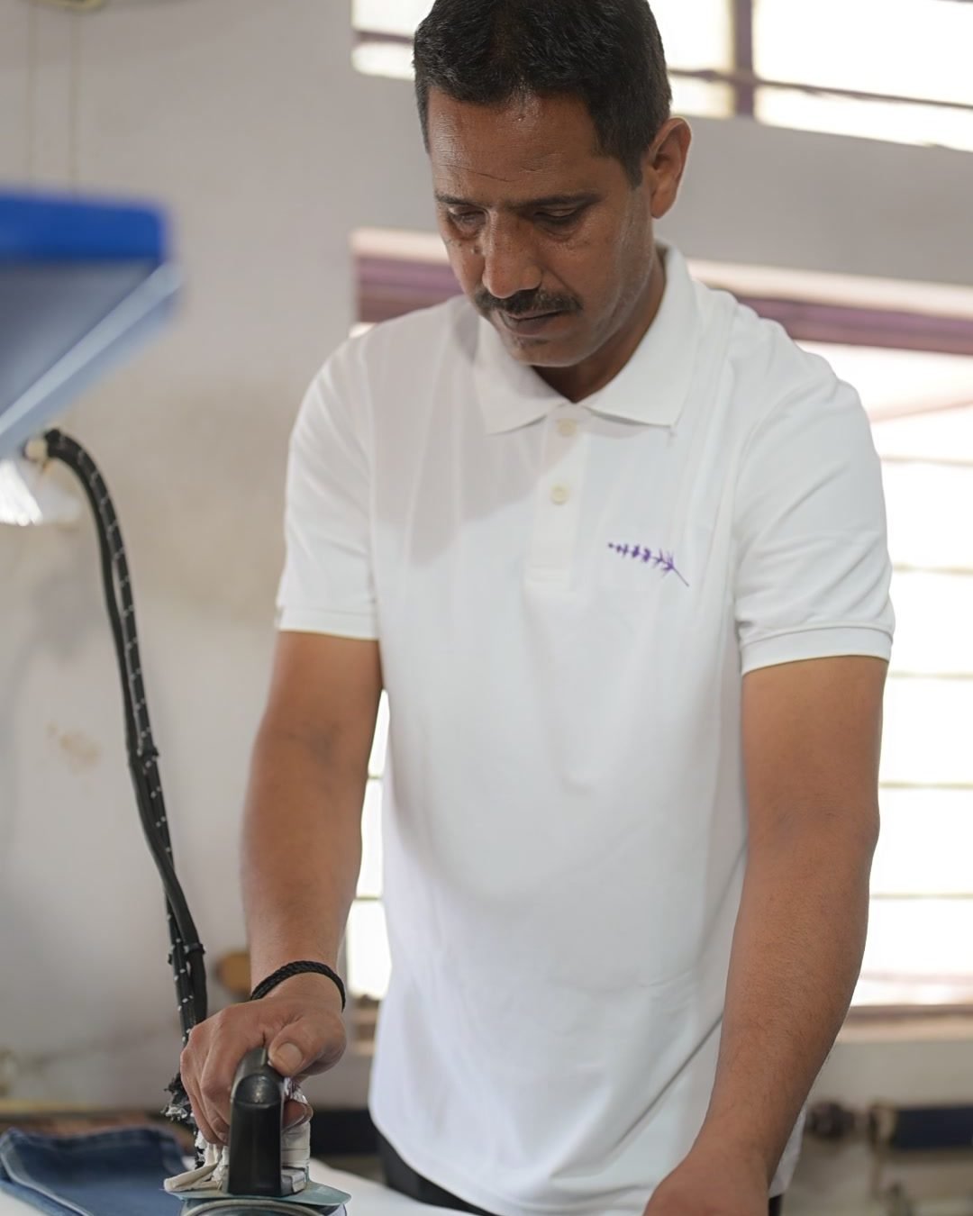 A Lavender technician finishing a garment on the professional steam press