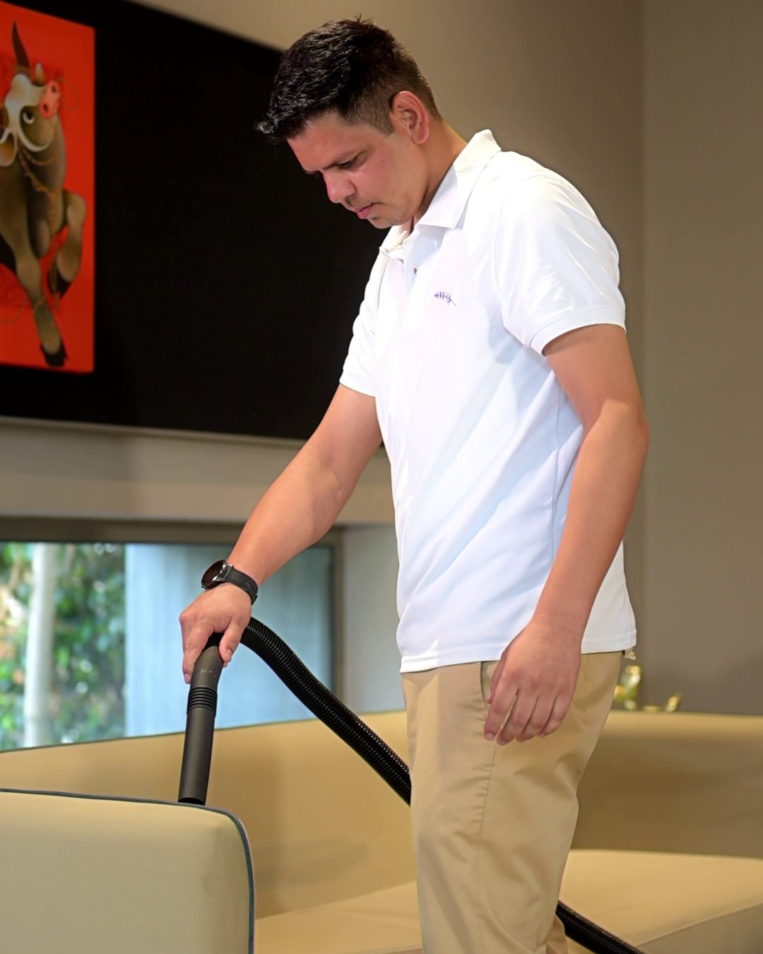 Housekeeper vacuuming a sofa